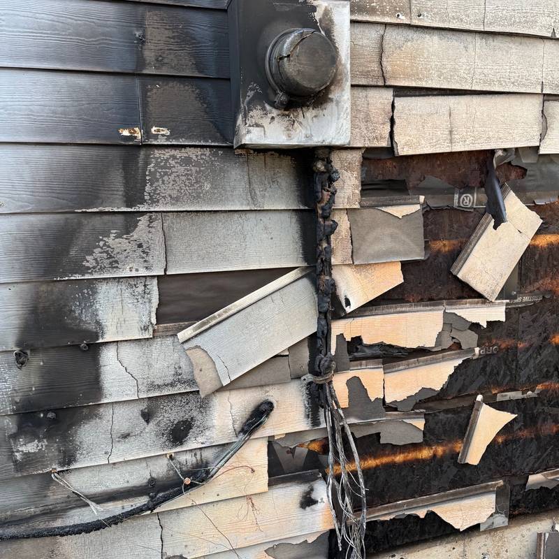 Fire damage around an electrical meter base and exterior siding
