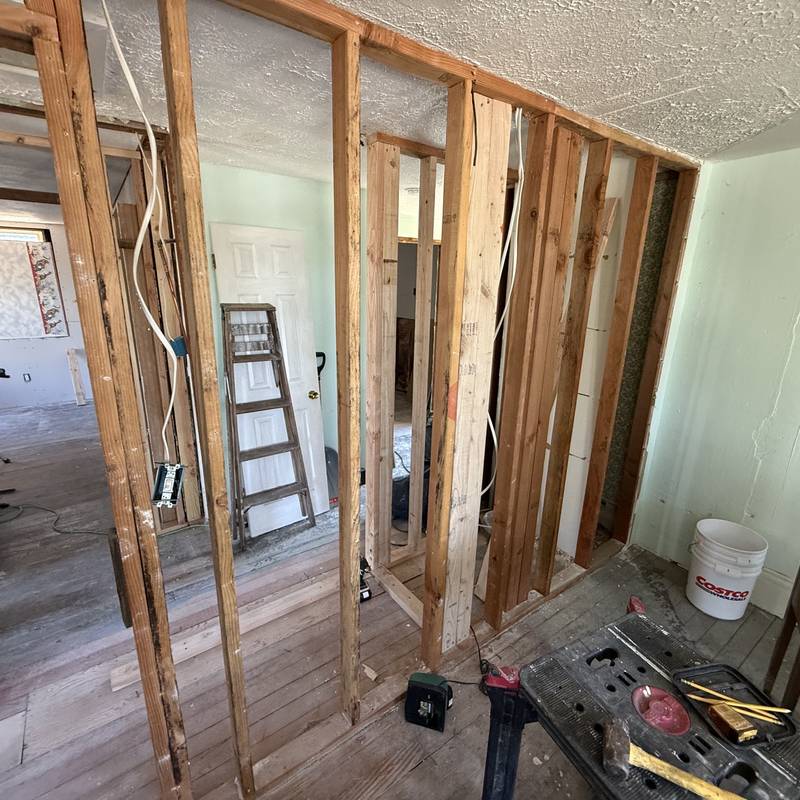 New electrical circuits run through open wall framing during a rewire