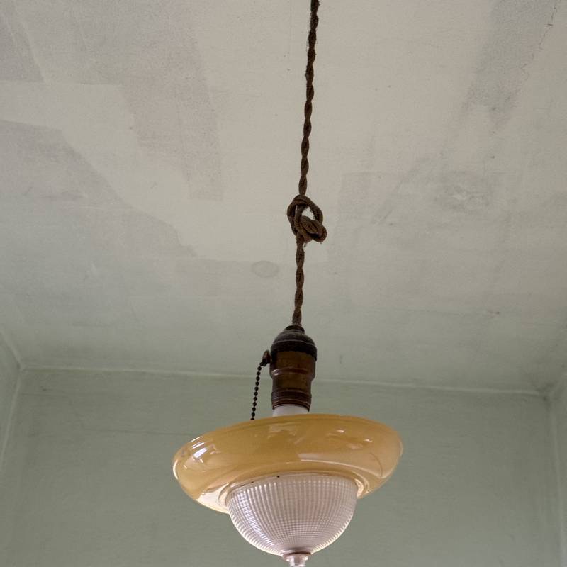 Vintage ceiling light hanging from original cloth-covered wiring